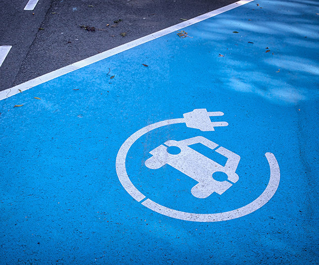 Logo 'charge your car here' on blue parking lot