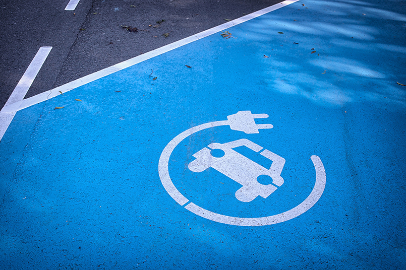 Logo 'charge your car here' on blue parking lot